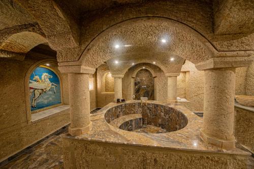 uma grande casa de banho com uma grande banheira de pedra num edifício em Ares Cave Suites em Goreme
