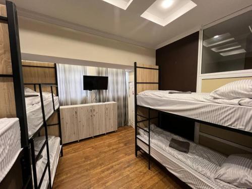 a room with three bunk beds and a television at Like Hostel in Chişinău