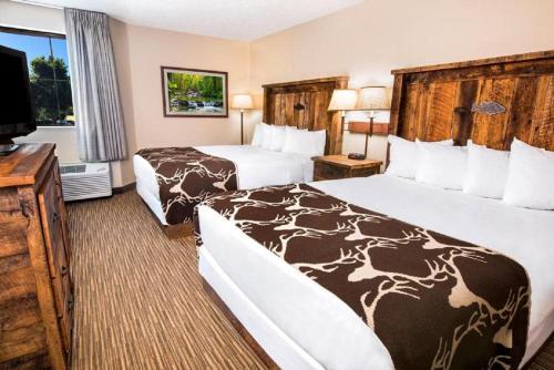 um quarto de hotel com duas camas e uma televisão de ecrã plano em Bass Pro Shops Angler's Lodge em Springfield