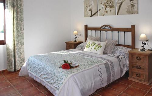 a bedroom with a bed with a white bedspread and a table with two lamps at Nice Home In Hornachuelos With Wifi in Hornachuelos