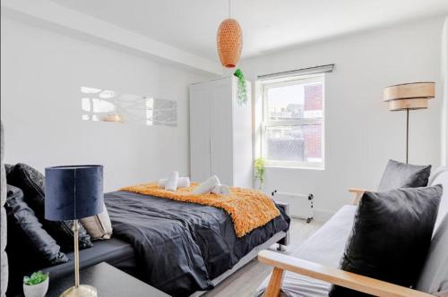 a bedroom with a bed and a couch at 1-Bed in Bricklane Shoreditch - 5 Sleeps in London