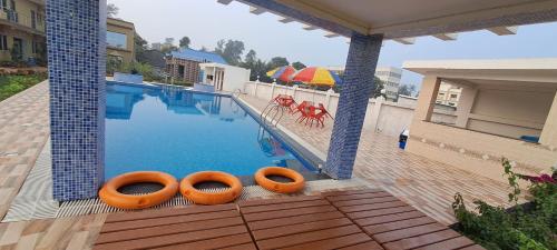 uma piscina com dois tubos insufláveis cor de laranja ao lado em Saikat Saranya Resort, #Mandarmoni #Beach em Mandarmoni