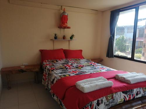 Un dormitorio con una cama roja con toallas. en Terracota Mirador Filandia en Filandia