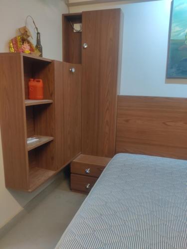 1 dormitorio con 1 cama y armario de madera en Essel tower ews falt 8 Floor, en Gurgaon