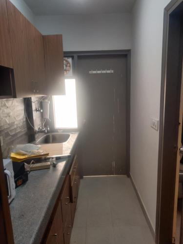 a kitchen with a door in the middle of a room at Essel tower ews falt 8 Floor in Gurgaon
