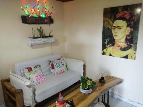 a living room with a white couch and a painting at Terracota Mirador Filandia in Filandia