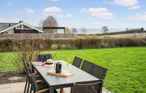 a table and chairs on a patio with a lawn at Cozy Home In Sjølund With Sauna in Sjølund