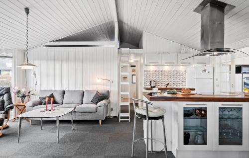 a kitchen and living room with a couch and a table at Cozy Home In Sjølund With Sauna in Sjølund