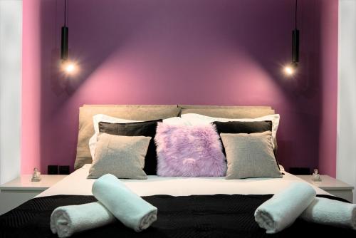 a bedroom with purple walls and a bed with pillows at Essél Noir - A hidden gem with a magnificent Acropolis view in Athens