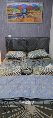 a bed with a blue comforter and pillows at Tower Basella no 2025 - Apartemen Springlake Summarecon Bekasi in Rawabugel