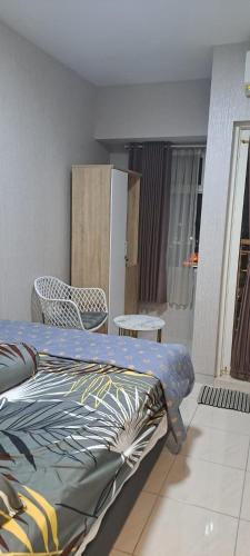 a bedroom with a bed and a table and a chair at Tower Basella no 2025 - Apartemen Springlake Summarecon Bekasi in Rawabugel