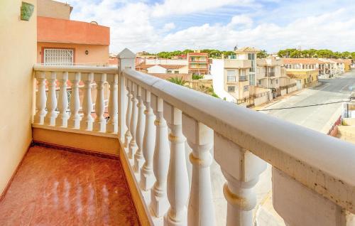 ein Balkon mit einem weißen Geländer und einer Straße in der Unterkunft Cozy Apartment In San Pedro Del Pinatar in San Pedro del Pinatar