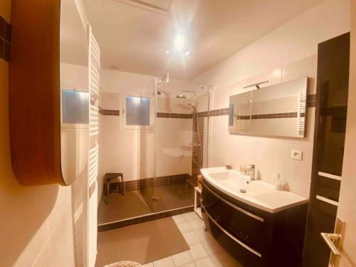 une salle de bain blanche avec un lavabo et une douche dans l'établissement Le Havre de Ré, au Bois-Plage-en-Ré