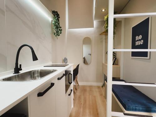 a small kitchen with a sink and a shelf at Apê Paulista Alameda Santos in São Paulo
