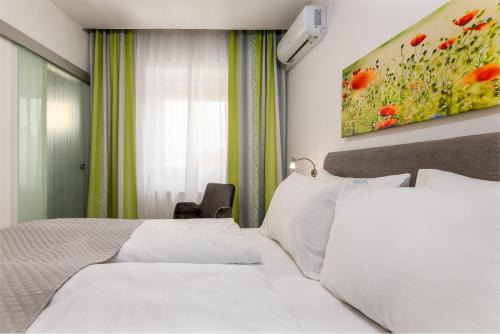 a bedroom with two beds and a painting on the wall at Hotel Zentral in Wiener Neustadt