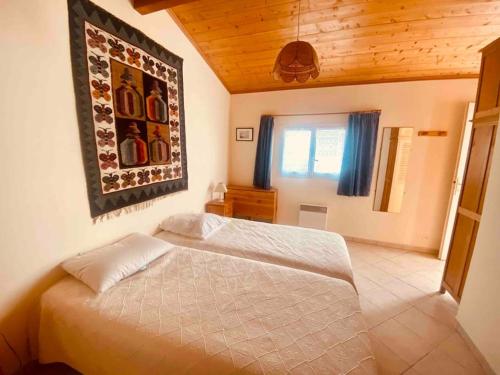 une chambre avec un lit blanc dans une pièce dans l'établissement Le Havre de Ré, au Bois-Plage-en-Ré