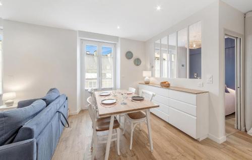 Il comprend une cuisine et un salon avec une table et un canapé bleu. dans l'établissement 1 Bedroom Nice Apartment In Saint-Malo, à Saint-Malo