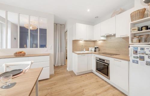 une cuisine avec des armoires blanches et une table en bois dans l'établissement 1 Bedroom Nice Apartment In Saint-Malo, à Saint-Malo