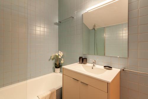een badkamer met een wastafel, een bad en een spiegel bij Villa Martins - Minho's Guest in Vieira do Minho