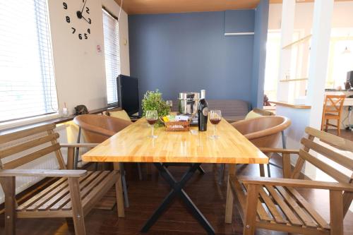 una mesa de madera con dos copas de vino. en Minowa airbnb en Yubari