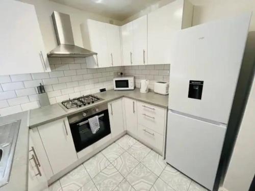 a white kitchen with a stove and a microwave at Suite 3 - Classic Private Room near City Centre in Liverpool