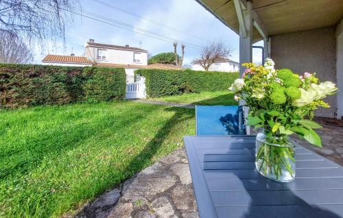 un vase de fleurs assis sur une table dans une cour dans l'établissement Pet Friendly Home In Royan With Wifi, à Royan