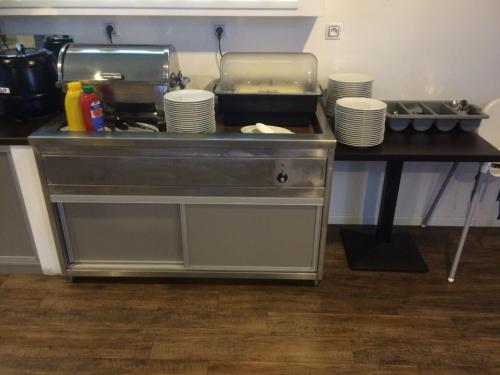 a kitchen with a counter with plates on a table at Promohotel Slavie in Cheb