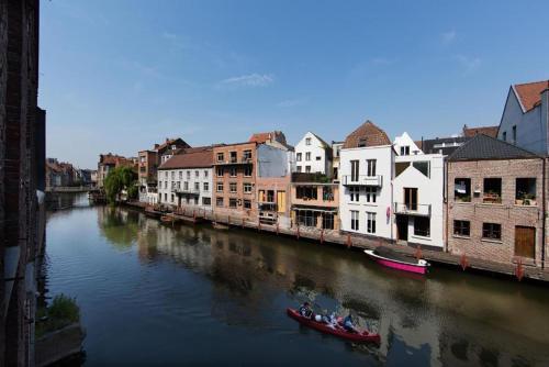 a group of people in a boat on a river at Budget Rooms by Ghent River in Ghent