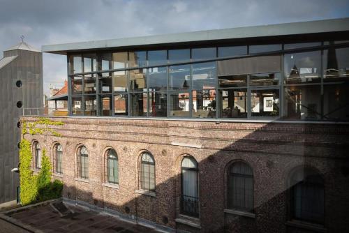 a building with a lot of windows on top of it at Budget Rooms by Ghent River in Ghent
