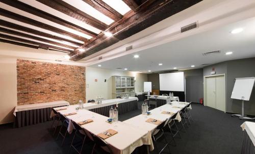 a conference room with tables and chairs and a brick wall at Budget Rooms by Ghent River in Ghent