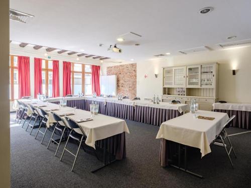 a dining room with tables and chairs and red curtains at Budget Rooms by Ghent River in Ghent