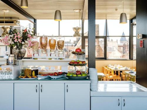 a kitchen with plates of food on a counter at Budget Rooms by Ghent River in Ghent