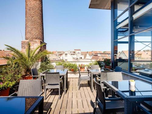 a patio with tables and chairs on a balcony at Budget Rooms by Ghent River in Ghent