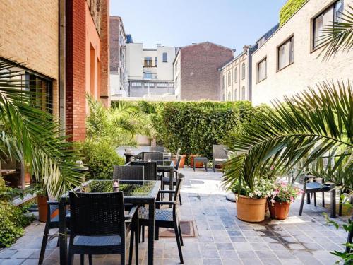 an outdoor patio with tables and chairs and plants at Budget Rooms by Ghent River in Ghent