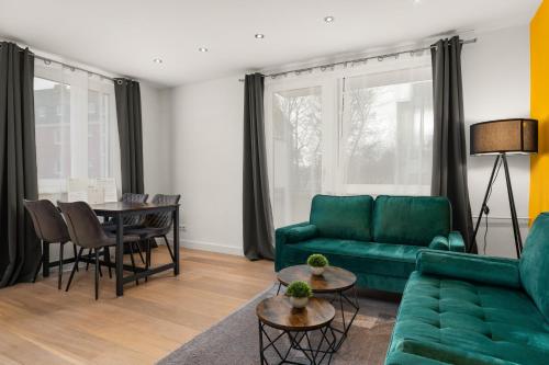 a living room with a green couch and a table at FREE LIVING - Jungle Design Apartments, Zentrum, Parkplatz, Küche, Wlan in Wolfsburg