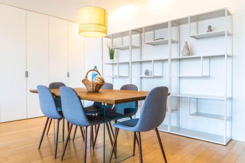 comedor con mesa de madera y sillas azules en Wave Break Apartment, en Livramento
