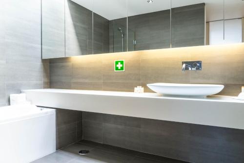 een badkamer met een witte wastafel en een spiegel bij Wave Break Apartment in Livramento