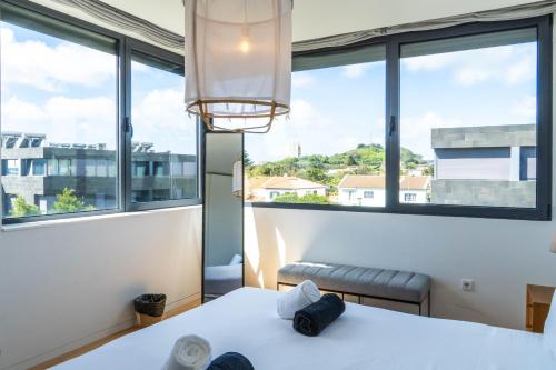 ein Schlafzimmer mit Bett und großen Fenstern in der Unterkunft Wave Break Apartment in Livramento