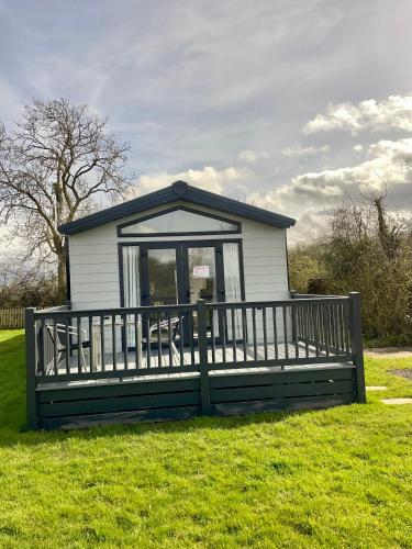 a small house with a porch in the grass at Modern homely Chalet in Tuxford in Askham