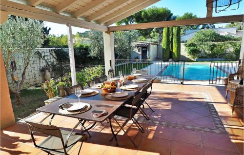 - une table sur une terrasse à côté de la piscine dans l'établissement Mas De L'eveil, à Paradou
