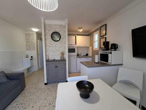 un salon et une cuisine avec un canapé et une table dans l'établissement Appartement RDC 2 pièces proche plage avec terrasses et parking - FR-1-326-575, à Marseillan