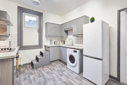 a kitchen with a refrigerator and a washer and dryer at Host & Stay - Clarendon Apartments in Redcar