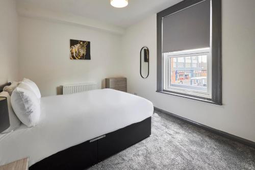 een slaapkamer met een groot wit bed en een raam bij Host & Stay - Clarendon Apartments in Redcar