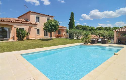 a swimming pool in a yard next to a house at 4 Bedroom Beautiful Home In Calvisson in Calvisson
