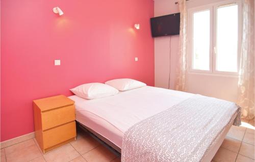 a bedroom with a bed with a red wall at 4 Bedroom Beautiful Home In Calvisson in Calvisson