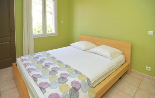 a bed in a green room with a bedspread and pillows at 4 Bedroom Beautiful Home In Calvisson in Calvisson