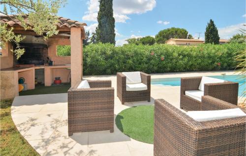 a patio with wicker chairs next to a pool at 4 Bedroom Beautiful Home In Calvisson in Calvisson