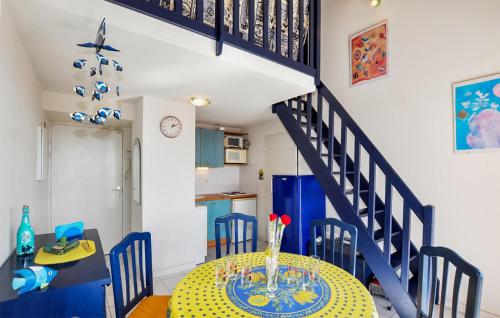 une salle à manger avec une table et un escalier bleu dans l'établissement Nice Apartment In Canet-En-Roussillon, à Canet