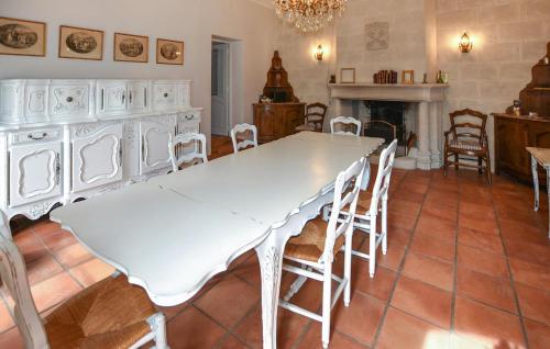 - une table et des chaises blanches dans une pièce avec cheminée dans l'établissement Lovely Home In Entraigues-Sur-La-Sorg, à Entraigues-sur-la-Sorgue