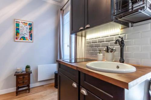 La salle de bains est pourvue d'un lavabo et d'un comptoir. dans l'établissement Ruby Magenta, à Paris